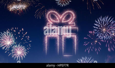 A dark night sky with a sparkling red firecracker in the shape of a gift composed into.(series) Stock Photo