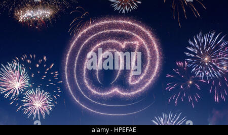 A dark night sky with a sparkling red firecracker in the shape of an at symbol composed into.(series) Stock Photo