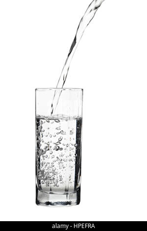 Water pouring into glass with air bubbles in the water isolated on white background Stock Photo