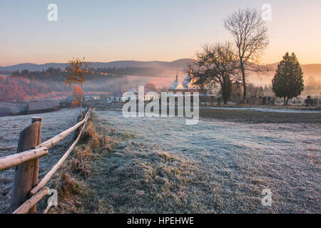 Autumn alpine landscape with church with hoarfrost on the ground Stock Photo