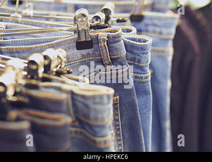 Blue jeans on hanger in store background with selective focus Stock Photo