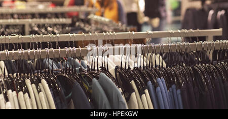 Clothes on hanger in store background blurred Stock Photo