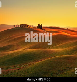 Tuscany, rural landscape in Crete Senesi land. Rolling hills, countryside farm, cypresses trees, green field on warm sunset. Siena, Italy, Europe. Stock Photo