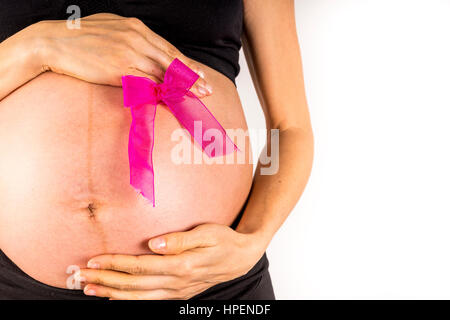 Mom holds pink ribbon on her belly Stock Photo