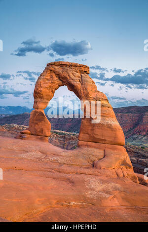 Classic postcard view of famous Delicate Arch, symbol of Utah and a popular scenic tourist attraction, in beautiful post sunset twilight at dusk, USA Stock Photo