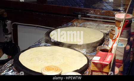 Hot sweet pancakes is being cooked on the street kitchen. Street food is popular for snack or lunch in big cities. Stock Photo