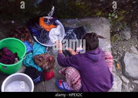 Nepalese Girl Washing Clothes Under a Tap in the Village of Tikhedhungga in the Annapurna Sanctuary, Himalayas, Nepal, Asia Stock Photo