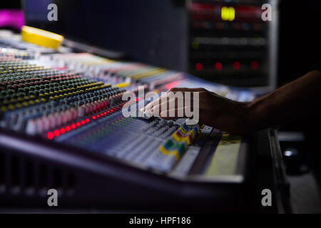 Soundman working on the mixing console. Hands on the sliders. Stock Photo