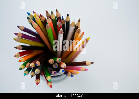 Colored pencils kept in pencil holder on white background Stock Photo