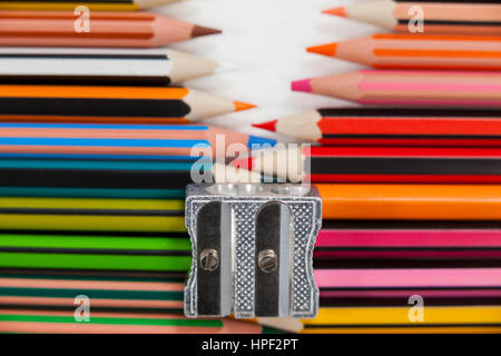 Close-up of colored pencils and sharpener on white background Stock Photo