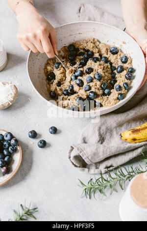 A woman's hands are photographed as she is mixing blueberry muffin batter. Stock Photo