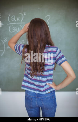 Rear view of schoolgirl pretending to be a teacher in classroom at school Stock Photo