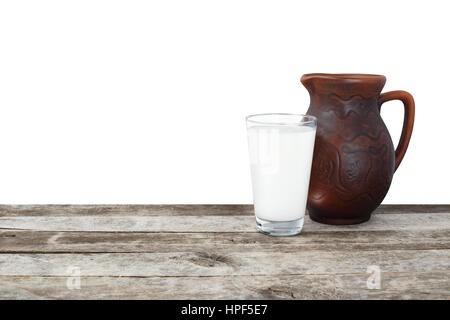 glass of milk and clay jug on old wooden table isolated on white background. Dairy product. Milk Stock Photo