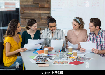 Graphic designers discussing over document in meeting at office Stock Photo