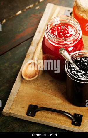 Fruit and berry jam with ingredients on a wooden background Stock Photo