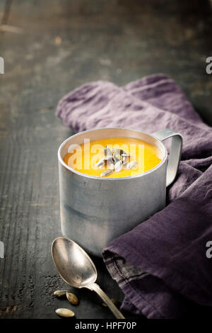 Pumpkin soup in a metal pot on a wooden surface Stock Photo