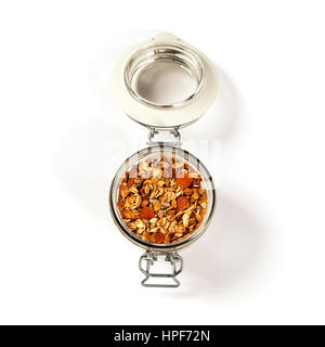 Homemade oatmeal granola with fruits and nuts in a glass jar on white background Stock Photo