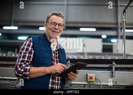 Portrait of smiling factory worker using digital tablet in the factory Stock Photo