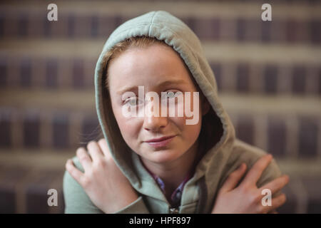 Sad schoolgirl sitting alone on staircase in school Stock Photo