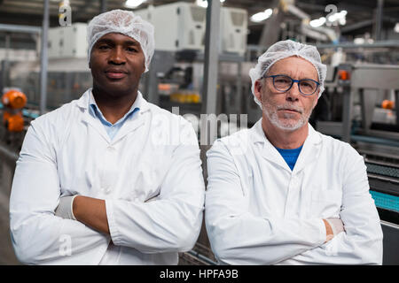 Portrait of two factory engineers standing with arms crossed in drinks production plant Stock Photo
