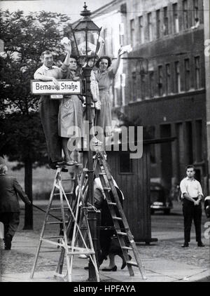 West Berliners stand on ladders to greet friends and loved ones on the eastern side of the Berlin Wall, West Berlin, Germany, 01/01/1961. Stock Photo