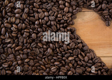 Coffee beans forming shape on wooden table Stock Photo