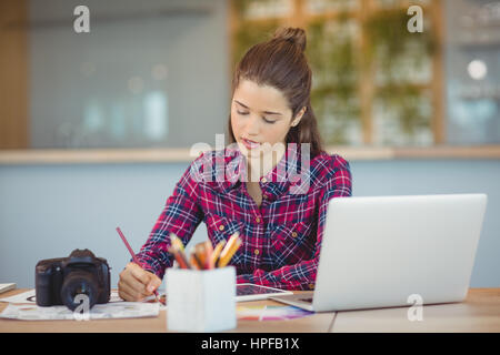 Attentive graphic designer sitting and table and working in office Stock Photo