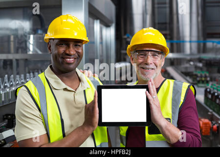 Portrait of factory workers holding digital tablet at drinks production plant Stock Photo