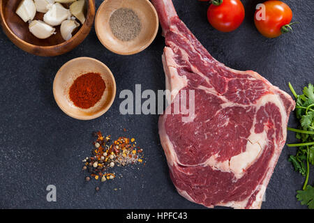 Sirloin chop and ingredients against black background Stock Photo