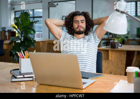 Portrait of graphic designer relaxing on chair in creative office Stock Photo