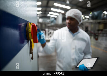 Factory engineer operating machine in drinks production plant Stock Photo