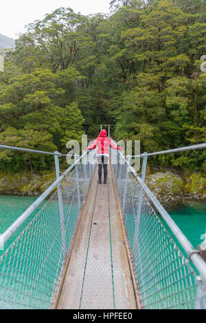 Woman crossing Suspension Bridge, Blue Pools, Haast Pass, West Coast, Southland, New Zealand Stock Photo