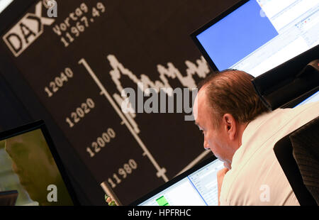 Frankfurt, Germany. 22nd Feb, 2017. The DAX curve can be seen on a display board of the stock exchange in Frankfurt, Germany, 22 February 2017. An employee watches. The leading German index DAX reached the 12 000 point mark again for the first time since April 2015. Photo: Arne Dedert/dpa/Alamy Live News Stock Photo