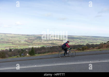 Ilkley, Yorkshire, UK. 22nd Feb, 2017. UK Weather. A cyclist battles strong winds on Ilkley Moor,Yorkshire near the famous Cow and Calf rocks as the UK prepares for stormdoris Credit: Windmill Images/Alamy Live News Stock Photo