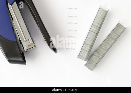 Blue stapler with staples and paper on white table Stock Photo