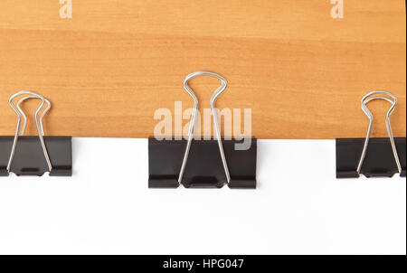 Three paperclips stapling papers on wood table Stock Photo