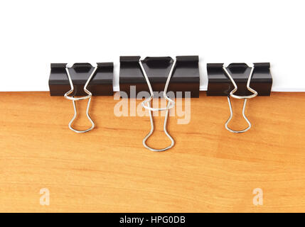 Three paperclips stapling papers on the wood table Stock Photo