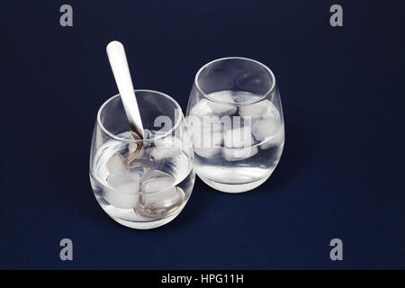https://l450v.alamy.com/450v/hpg11h/glasses-with-water-and-ice-isolated-on-dark-blue-hpg11h.jpg