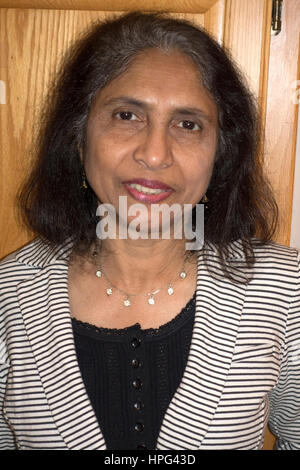 beautiful mature woman in Indian dress posing on red background, toned