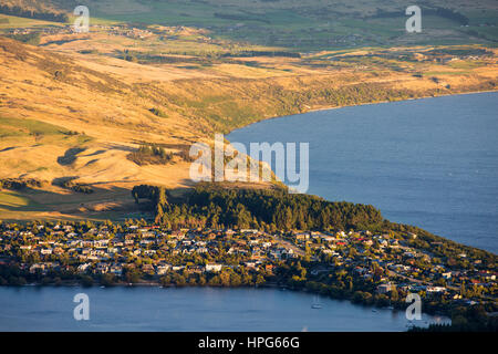 Queenstown, Otago, New Zealand. View to the exclusive suburb of Kelvin Heights and the northern shore of Lake Wakatipu, sunset. Stock Photo