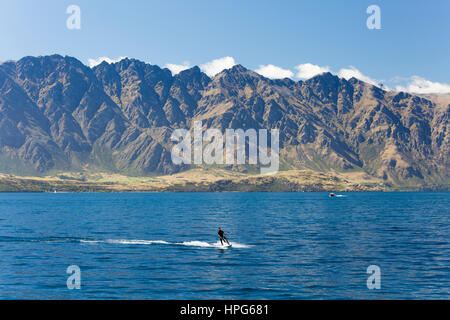 Queenstown, Otago, New Zealand. Jet skiing on Lake Wakatipu, the Remarkables in background. Stock Photo