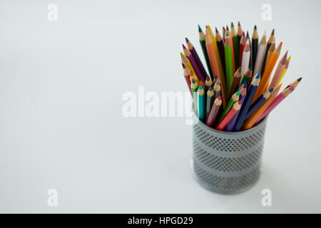 Colored pencils kept in pencil holder on white background Stock Photo