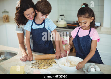 Mother and kids preparing cookies in kitchen at home Stock Photo