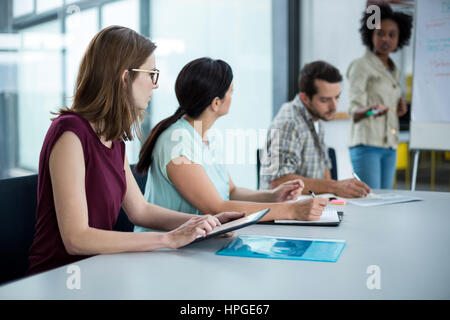 Business executive using digital tablet in meeting at office Stock Photo