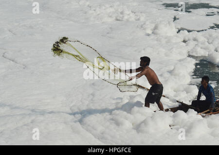 Fishermen throwing net in polluted river near Pune Stock Photo