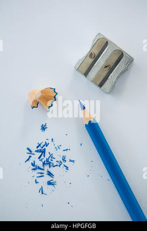 Close-up of red color pencil with pencil shaving and sharpener on white background Stock Photo
