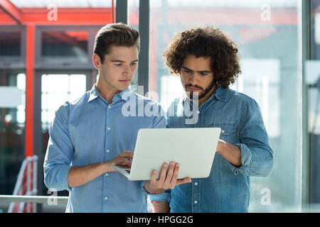 Two business executives working on laptop in office Stock Photo