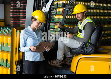 Attentive factory workers checking record on clipboard in factory Stock Photo