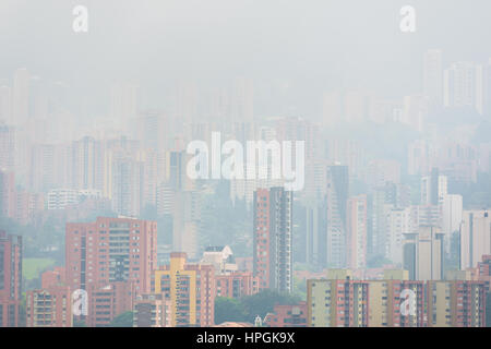 High rise luxury apartment buildings of El Poblado neighborhood are seen submerged in a morning fog, rolling on the hills of Medellín, Colombia. Stock Photo