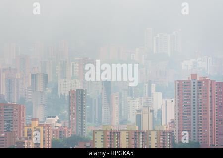 High rise luxury apartment buildings of El Poblado neighborhood are seen submerged in a morning fog, rolling on the hills of Medellín, Colombia. Stock Photo